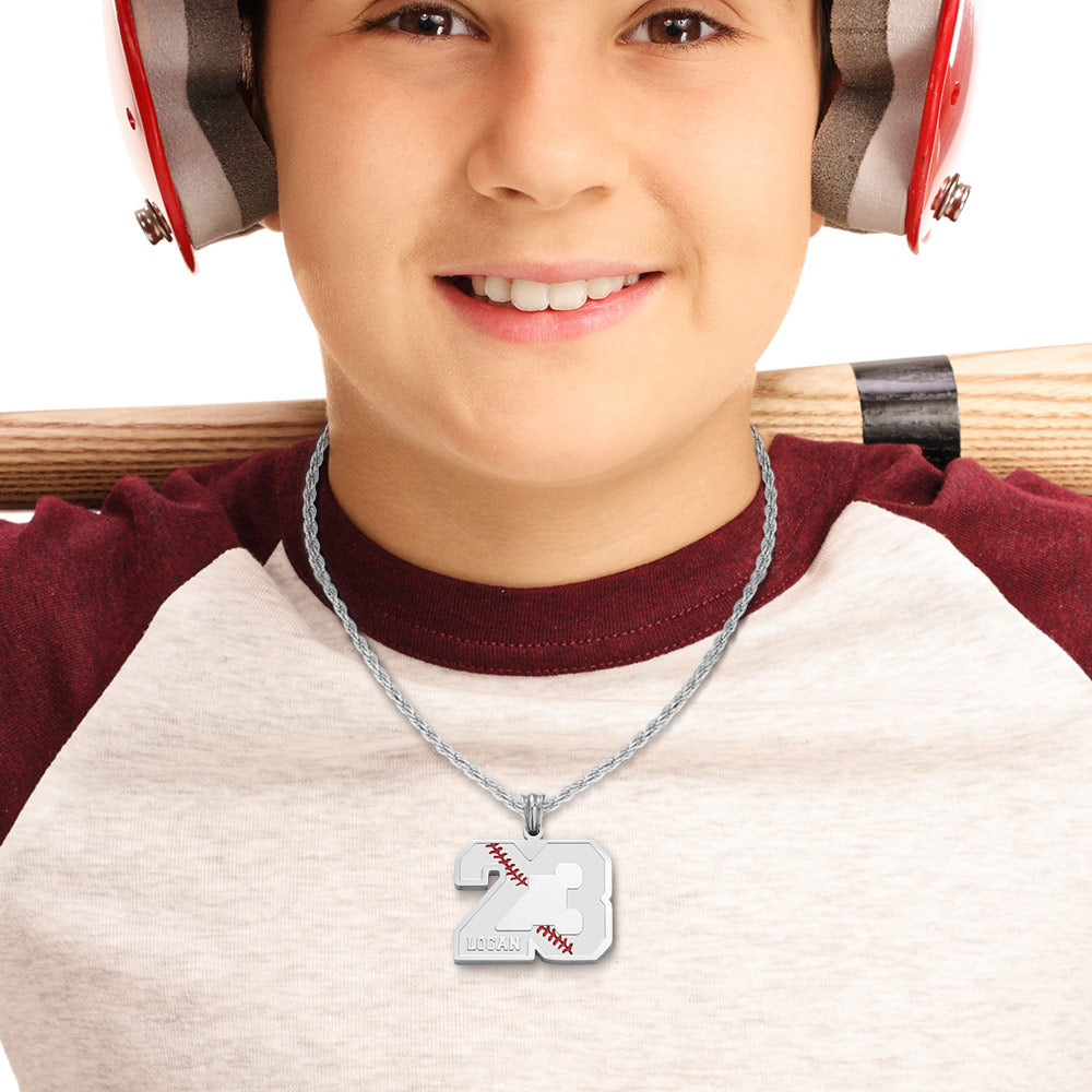 A boy is wearing a silver custom baseball sport number necklace with his name Logan engraved 